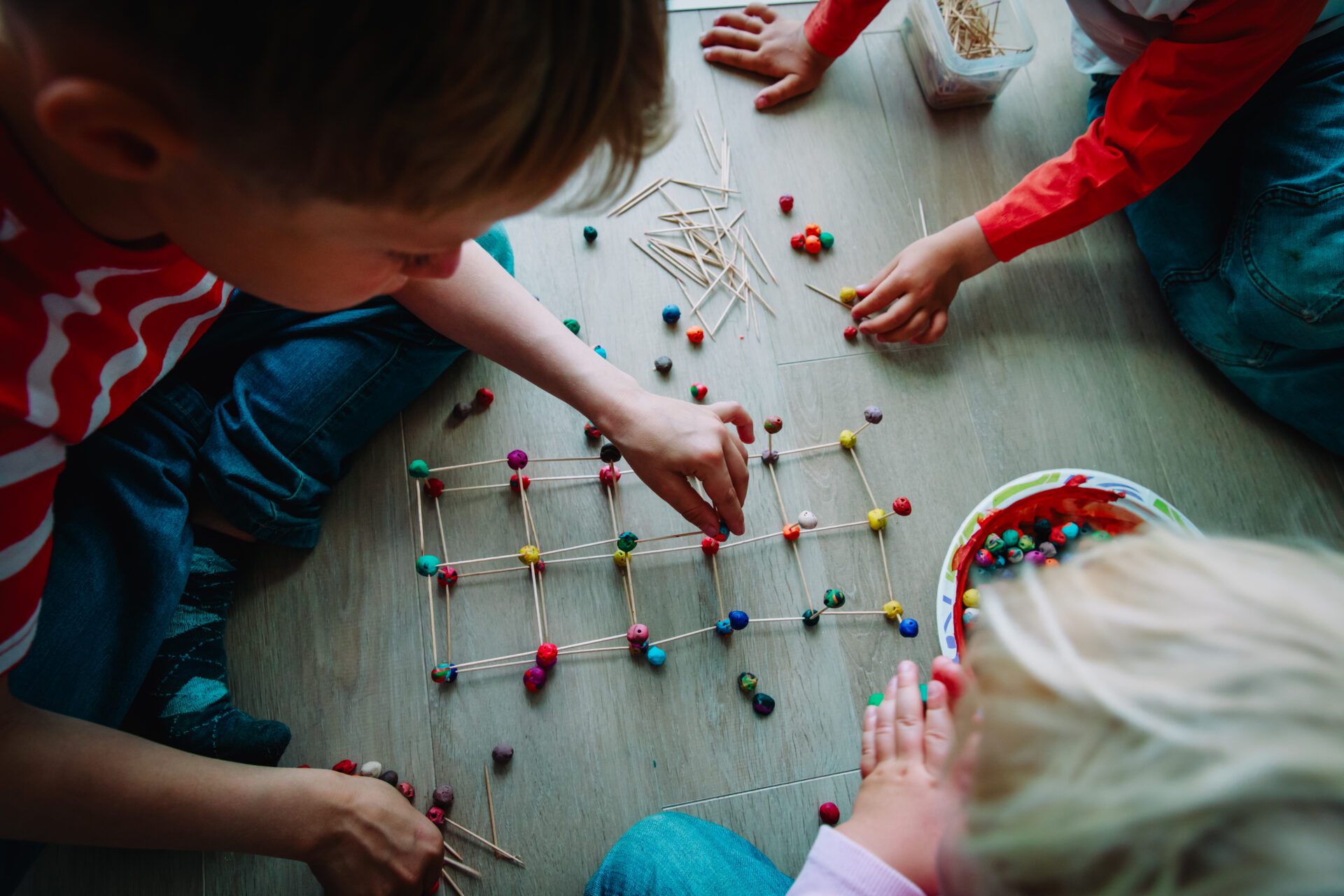 kids making geometric shapes from sticks and play dough